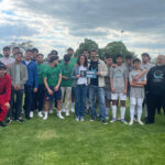 Eine große Gruppe, darunter Fußballspieler in Sportkleidung und andere in Freizeitkleidung, posieren nach dem Players for Purpose Cup gemeinsam auf einer Wiese. Einige Spieler halten eine Urkunde und einen Pokal für den 6. Platz und ein Preisgeld von 750 Euro in der Hand.
